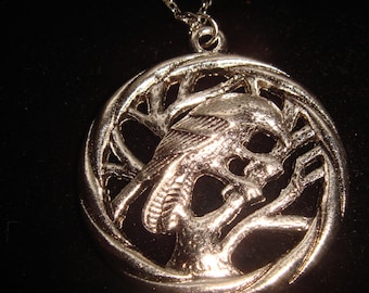May include: Silver pendant necklace featuring an owl perched on a tree branch, with a circular, openwork design.