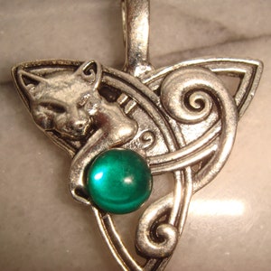 May include: Silver Celtic knot pendant with a green gemstone and a cat design.