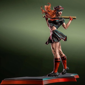 May include: A statue of a woman in a black baseball uniform, holding a baseball bat. The figure has red hair, a black cap, and red and black socks. The base is black and red.