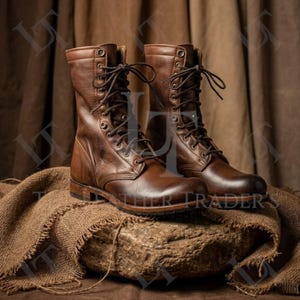 Könnte beinhalten: Ein Paar braune Leder-Kampfstiefel mit Schnürsenkeln. Die Stiefel werden auf einer Steinoberfläche mit einem Jutegewebe präsentiert. Die Stiefel haben ein klassisches Design mit mehreren Ösen und einer robusten Sohle.