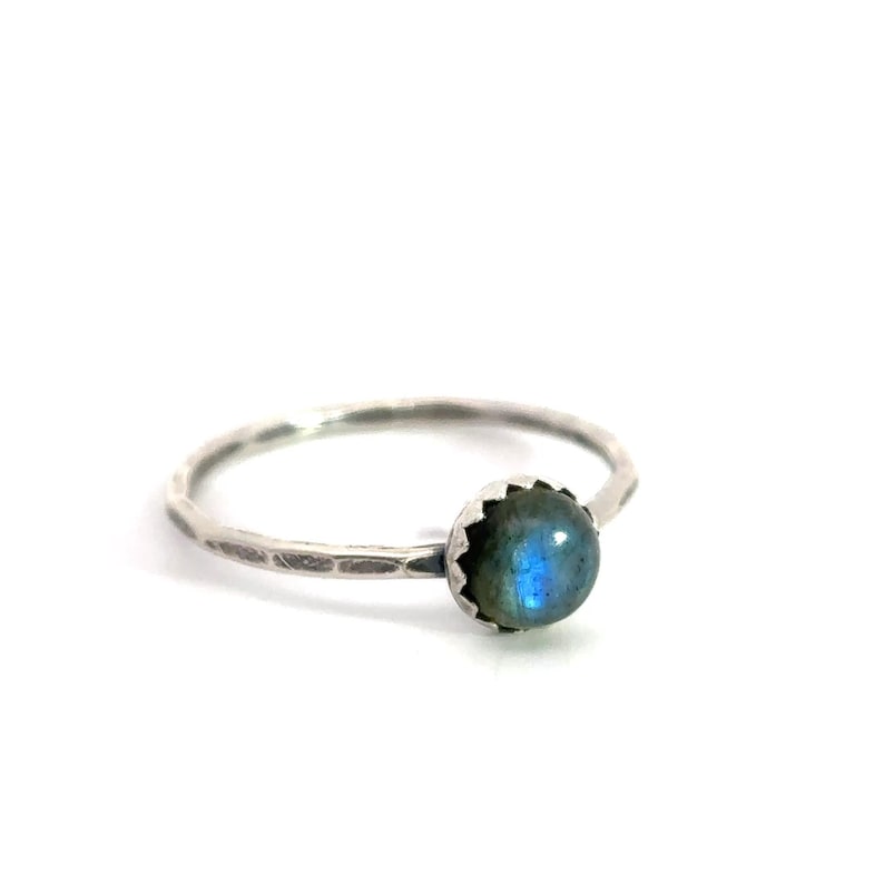 K&ouml;nnte beinhalten: Ein silberner Ring mit einem blauen und gr&uuml;nen Labradorit-Edelstein, der in einem strukturierten Band gefasst ist.