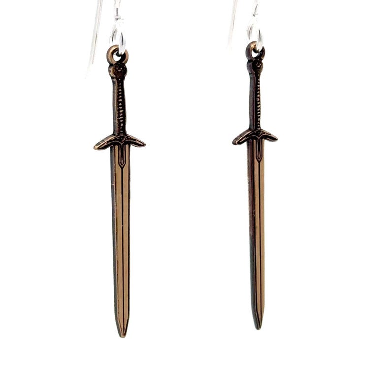 Peut inclure: Une paire de boucles d'oreilles en argent avec des breloques en forme d'&eacute;p&eacute;e en bronze. Les &eacute;p&eacute;es ont un design d&eacute;taill&eacute; et une pointe pointue.