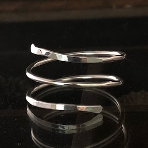 May include: A silver, triple-wrap ring with a hammered finish.