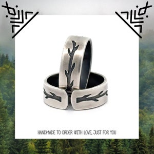 May include: Two silver rings with a black tree branch design. The rings are stacked on top of each other. "Handmade to order with love, just for you" is written below the rings.