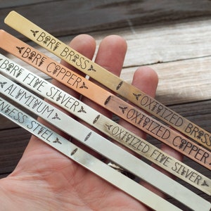 May include: Close-up of six metal strips, each labeled with a different metal type: Bare Brass, Bare Copper, Bare Fine Silver, Aluminum, Stainless Steel, Oxidized Fine Silver, Oxidized Copper, and Oxidized Brass.