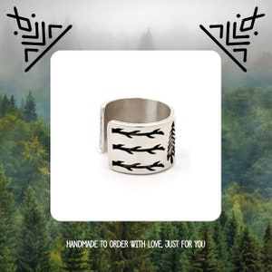 May include: A silver ring with a design of a tree and branches. The ring is handmade and has a minimalist style.