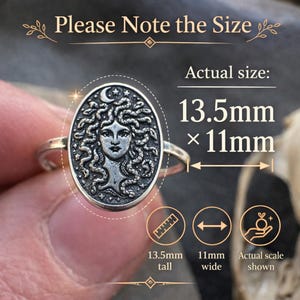 May include: A silver-toned ring featuring an oval face with a relief of a face surrounded by snakes, stars, and a crescent moon. Text on the image reads: Please Note the Size, Actual size: 13.5mm x 11mm, 13.5mm tall, 11mm wide, Actual scale shown.