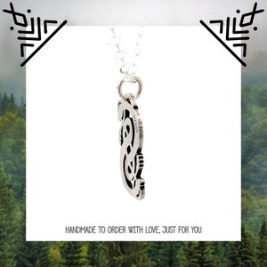 May include: Silver pendant necklace featuring a detailed, intricate design of a snake. The pendant is hanging from a silver chain.