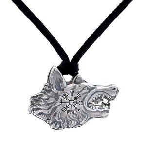 May include: Silver pendant necklace featuring a wolf head with a compass design and runes. The necklace has a black cord.