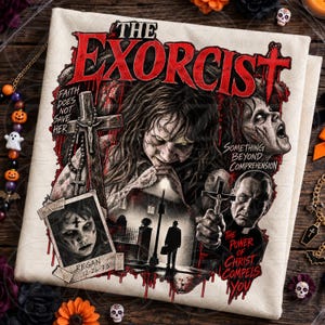 Könnte beinhalten: Ein cremefarbenes T-Shirt mit einem Grafikdruck zum Film Der Exorzist. Das Design zeigt den Titel in Rot, Bilder von Regan, einen Priester mit einem Kreuz, eine Straßenszene sowie den Text Faith Does Not Save Her und The Power Of Christ Compels You.