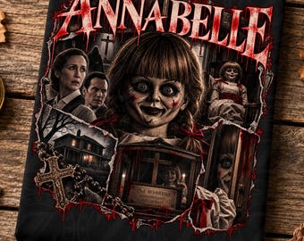 May include: A rectangular black fabric print featuring the title ANNABELLE in red dripping letters. The graphic displays the doll, two people, a house, a cross, and a display case labeled THE WARRENS DEMONOLOGY WITCHCRAFT in a collage style.