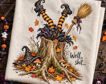 May include: A cream-colored fabric featuring a graphic of a tree stump with a witch's legs in orange and black striped stockings sticking out of the top. A broom, a witch's hat, and autumn leaves surround the stump with the text Well, shit...
