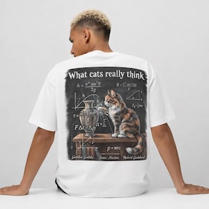 May include: White t-shirt with a graphic on the back that reads "What cats really think." The graphic features a cat, mathematical equations, and the names Galileo Galilei, Isaac Newton, and Robert Goddard.