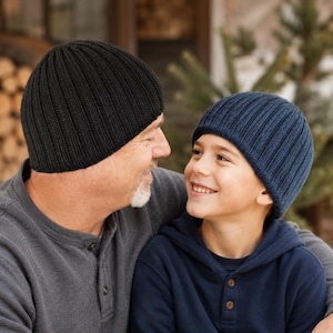 May include: A black ribbed knit beanie and a navy blue ribbed knit beanie. Both beanies feature a classic vertical ribbed texture and a rounded crown design, providing a simple and functional headwear option for cold weather conditions.