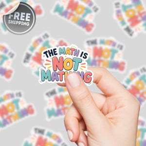 May include: A vibrant sticker with the phrase "THE MATH IS NOT MATCHING" in a fun font. The sticker, held by a hand, has a white border. The background shows similar stickers with the same text, creating a pattern.