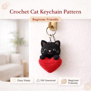 Könnte beinhalten: Ein schwarzer Häkel-Katzen-Schlüsselanhänger, der ein rotes Herz hält. Der Schlüsselanhänger ist an einem Metallring befestigt. Der Text auf dem Bild lautet "Crochet Cat Keychain Pattern" und "Beginner Friendly". Zusätzlicher Text enthält "Easy Steps" und "PDF Download".