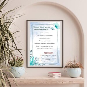 May include: A framed print with Spanish text, featuring a light blue background and floral accents. The text lists actions to take when feeling overwhelmed, with a reminder at the bottom. The print is displayed on a shelf with potted plants and books.