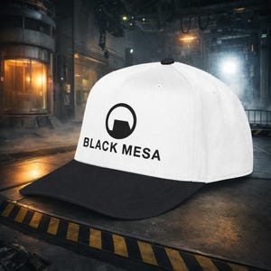 Puede incluir: Gorra de béisbol blanca y negra con el texto "BLACK MESA" y un logotipo circular. La gorra tiene una visera negra y un botón negro. El sombrero está sobre una superficie metálica.