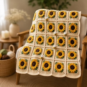 May include: A handmade crochet blanket featuring a grid of square motifs, each displaying a yellow and brown sunflower with green leaves on a cream background. Small, three-dimensional crocheted bees are attached to several of the squares.