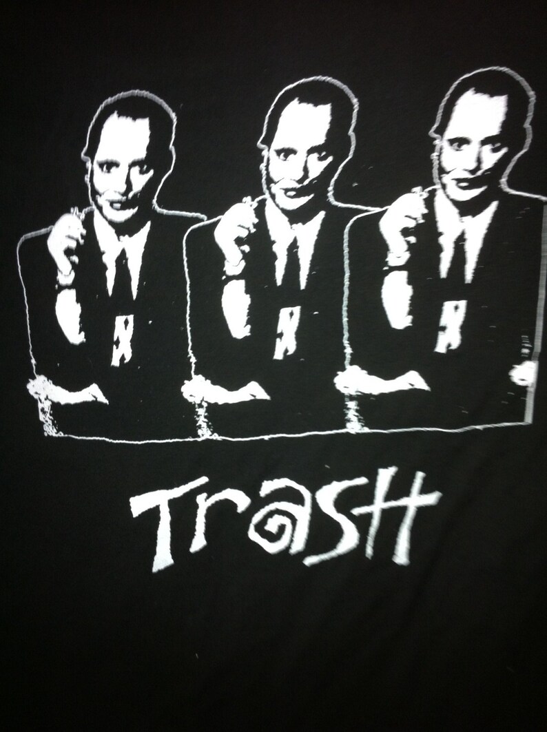 May include: Black and white graphic print of three men wearing suits and ties. The word "Trash" is printed below the men.