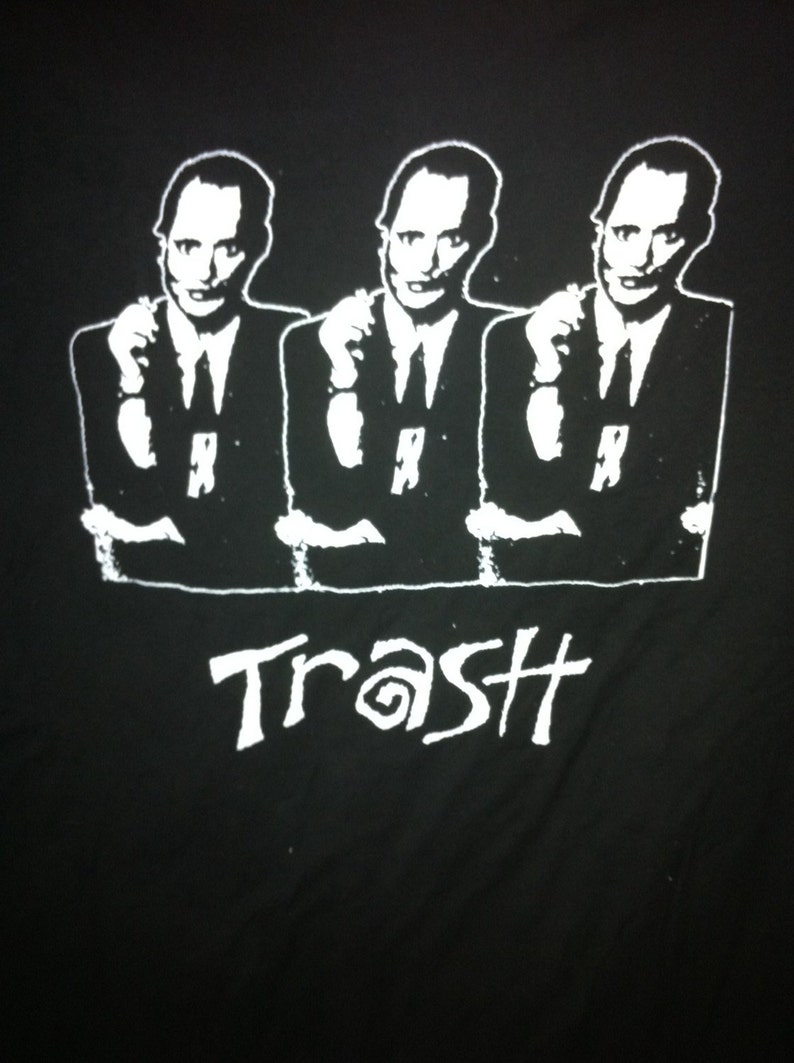 May include: Black and white graphic t-shirt featuring three men in suits with the word "Trash" printed below them.