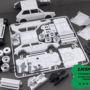 May include: A disassembled model car kit with various gray plastic parts, including car body sections, wheels, and chassis components. The kit is laid out on a dark surface, with some parts still attached to the sprue. A green badge with text is visible.