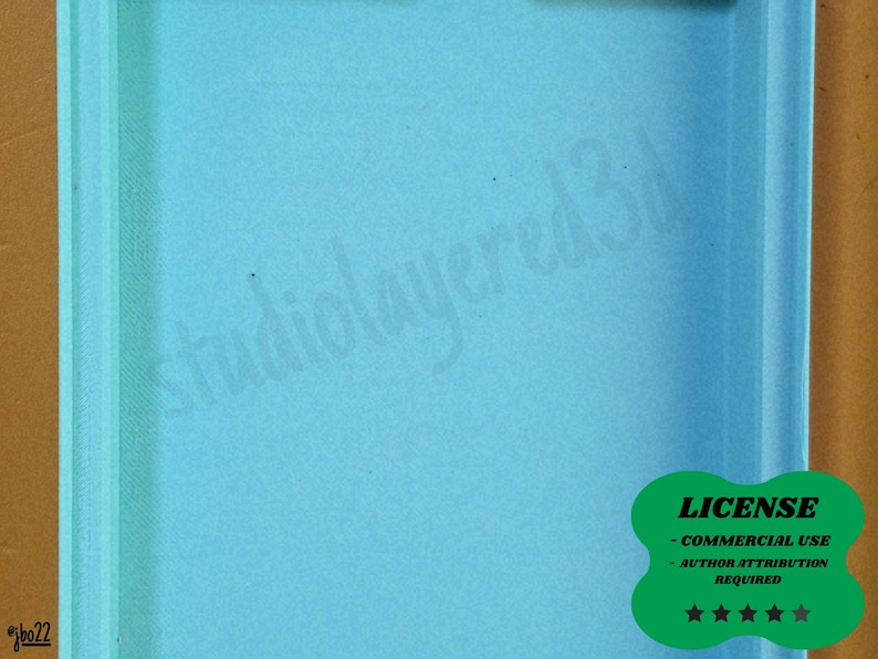 May include: A light blue rectangular object with a textured surface. The text "studiolayered3d" is faintly visible. A green sticker in the lower right corner states "LICENSE - COMMERCIAL USE - AUTHOR ATTRIBUTION REQUIRED" with five stars.