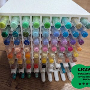 May include: A white pen holder filled with a variety of colourful markers. The markers are arranged in rows, showcasing a spectrum of colours. The image includes a green badge with the text "LICENSE - COMMERCIAL USE - AUTHOR ATTRIBUTION REQUIRED".