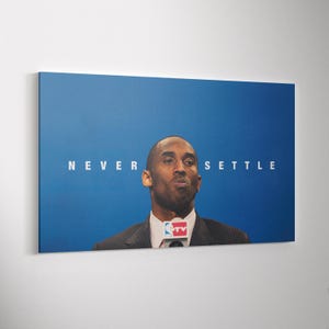 Può includere: Stampa su tela raffigurante un uomo in giacca e cravatta su sfondo blu. Le parole "NEVER SETTLE" sono stampate in bianco. L'uomo indossa giacca e cravatta ed è in piedi davanti a un microfono.