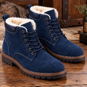 Könnte beinhalten: Ein Paar marineblaue Stiefeletten mit weichem, cremefarbenem Kunstfellfutter, passenden marineblauen Schnürsenkeln, silberfarbenen Metallösen, einem dunkelblauen gepolsterten Schaftrand und einer dicken braunen Profilsohle mit weißen Nähten.