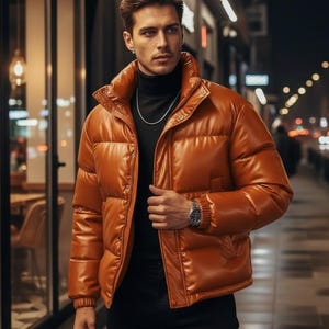 May include: A shiny, orange puffer jacket with a high collar and button closure. The jacket is worn over a black turtleneck and paired with black pants. A silver watch and chain are visible. The image is taken outdoors at night.