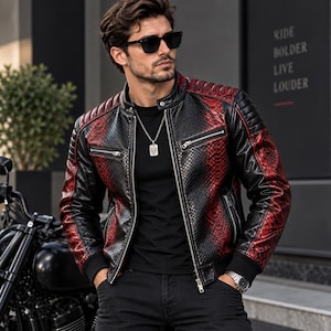 May include: A black and red snakeskin-patterned leather jacket with a mandarin collar, quilted shoulder detailing, silver-tone zippered chest pockets, and black ribbed cuffs. The jacket features a full-length front zipper and a sleek, fitted design.