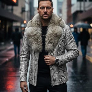 May include: A light grey and black snakeskin-patterned jacket with a large fur collar. The person is wearing a black top and trousers. A silver watch is visible on the wrist. The jacket has a zip closure.