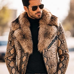 May include: A jacket with a brown and black snakeskin pattern featuring a large, thick, fluffy brown faux fur collar. The jacket has a silver-toned metal zipper closure and is worn over a black turtleneck sweater with dark sunglasses.