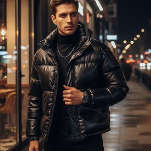 May include: A black puffer jacket with a high collar. The jacket is worn over a black turtleneck and paired with black pants. A silver chain and a watch are visible. The background shows a city street at night.