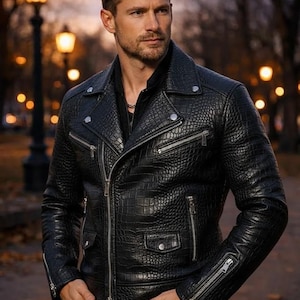 May include: Black leather motorcycle jacket with a textured, crocodile-like pattern. Features a notched collar, multiple zippered pockets, and silver hardware. A classic biker jacket style.