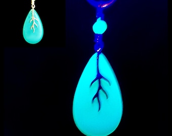 Collar de vidrio de uranio en forma de lágrima verde azulado mate brillante con colgante con detalle de ramita plateada.