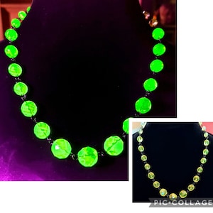May include: A necklace made of green glass beads with a black metal chain. The beads are round and have a faceted surface. The necklace is shown in two different lighting conditions, one with a bright light and one with a dim light.