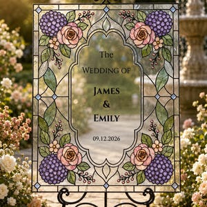 May include: A rectangular stained glass wedding sign featuring a black metal frame and stand. The glass displays floral motifs of purple hydrangeas and pink roses with green leaves. The center text reads: The WEDDING OF JAMES & EMILY 09.12.2026.