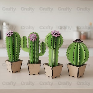 May include: Four laser-cut wooden cactus sculptures in light tan square pots. Each green cactus features a distinct shape and a layered pink flower on top. The structures are assembled from interlocking flat pieces with visible dark edges.