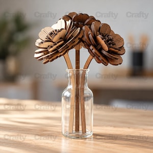 May include: A clear glass bottle containing three laser-cut wooden flowers with layered petals in varying shades of brown. Each flower is attached to a thin, flat wooden stem, creating a structured, multi-dimensional floral arrangement.