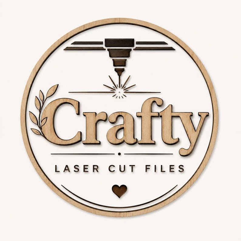 May include: A circular wooden sign featuring the word Crafty in large, light-colored letters. Above the text is a dark laser head icon with rays, and below is the text LASER CUT FILES with a small heart icon. The design has a light wood border.
