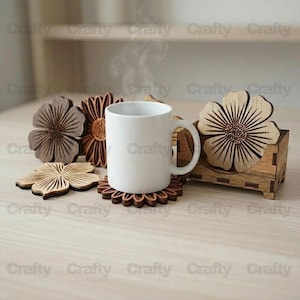 May include: A white ceramic mug with steam rising, placed on a wooden coaster. Several laser-cut wooden flower coasters and a holder are arranged around the mug. The coasters are various shades of brown and tan. The word "Crafty" is visible in the image.