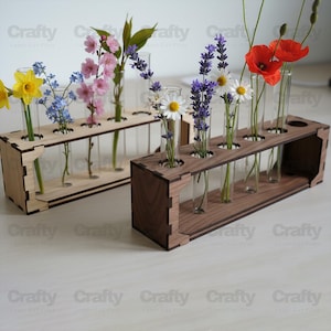 May include: Two rectangular wooden propagation stations with clear glass test tubes. One station is light-colored wood, the other is dark walnut. Each holds various fresh flowers including yellow daffodils, pink blossoms, lavender, and red poppies.