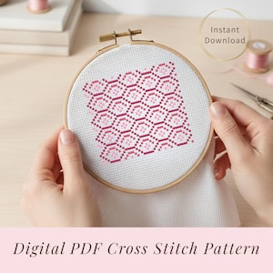 May include: A cross-stitch pattern in a wooden embroidery hoop. The design features a geometric pattern in shades of pink. The text "Instant Download" is in a gold circle. The words "Digital PDF Cross Stitch Pattern" are at the bottom.