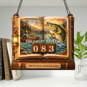 Puede incluir: Letrero de madera con forma de libro abierto, con una ilustración de una escena de pesca. El letrero dice "FISH CAUGHT THIS YEAR" encima del número "083". La parte inferior del letrero dice "MICHAEL'S ANGLER LOG". Una linterna cuelga en el lado izquierdo del libro.