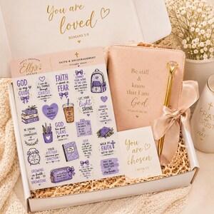 May include: A gift box containing a sheet of purple-themed faith stickers, a blush pink journal embossed with 'Be still & know that I am God', a gold pen with a diamond-like topper, and a card reading 'You are chosen' with 1 Peter 2:9 text.