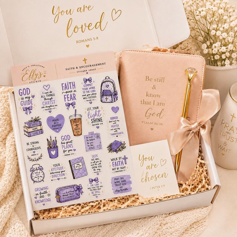 May include: A gift box containing a sheet of purple-themed faith stickers, a blush pink journal embossed with 'Be still & know that I am God', a gold pen with a diamond-like topper, and a card reading 'You are chosen' with 1 Peter 2:9 text.