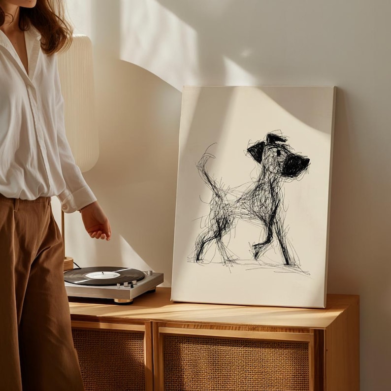 May include: A canvas print featuring a black and white abstract dog illustration. The artwork depicts a dog in a walking pose, created with expressive, scribbled lines. The print is displayed on a wooden cabinet.