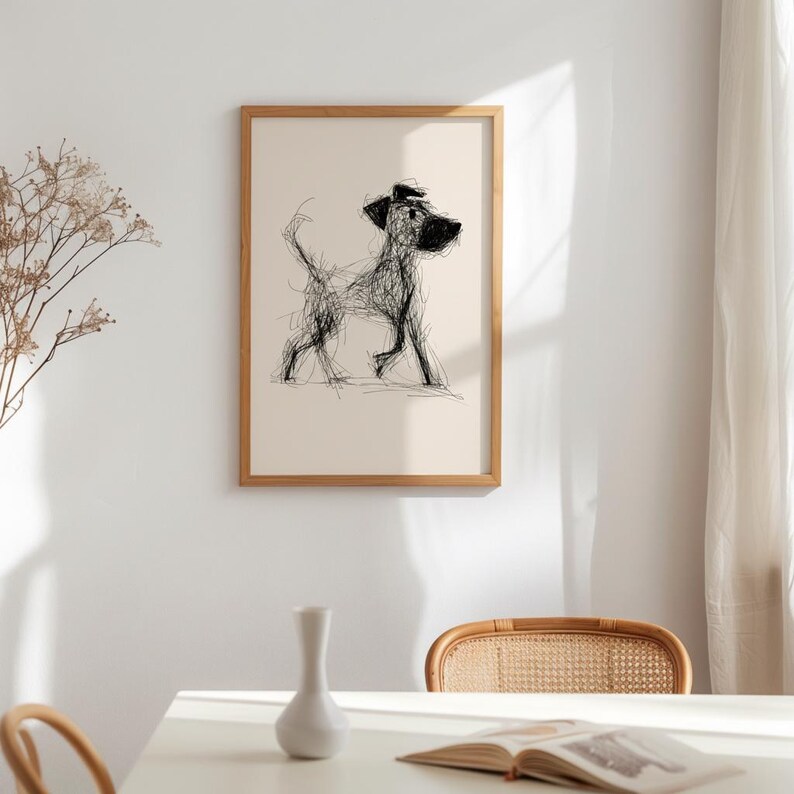May include: A framed art print featuring a minimalist sketch of a dog in black lines on a cream background. The dog is depicted in a walking pose, with a simple, expressive style. The frame is a light wood color, adding a natural touch to the artwork.